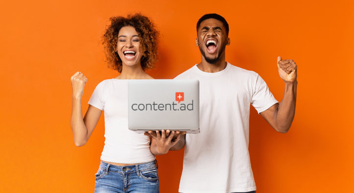 Excited black couple celebrating win with laptop